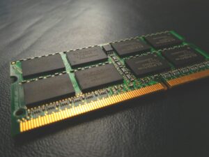 Stick of laptop memory on a black table, highlighting individual chip dies